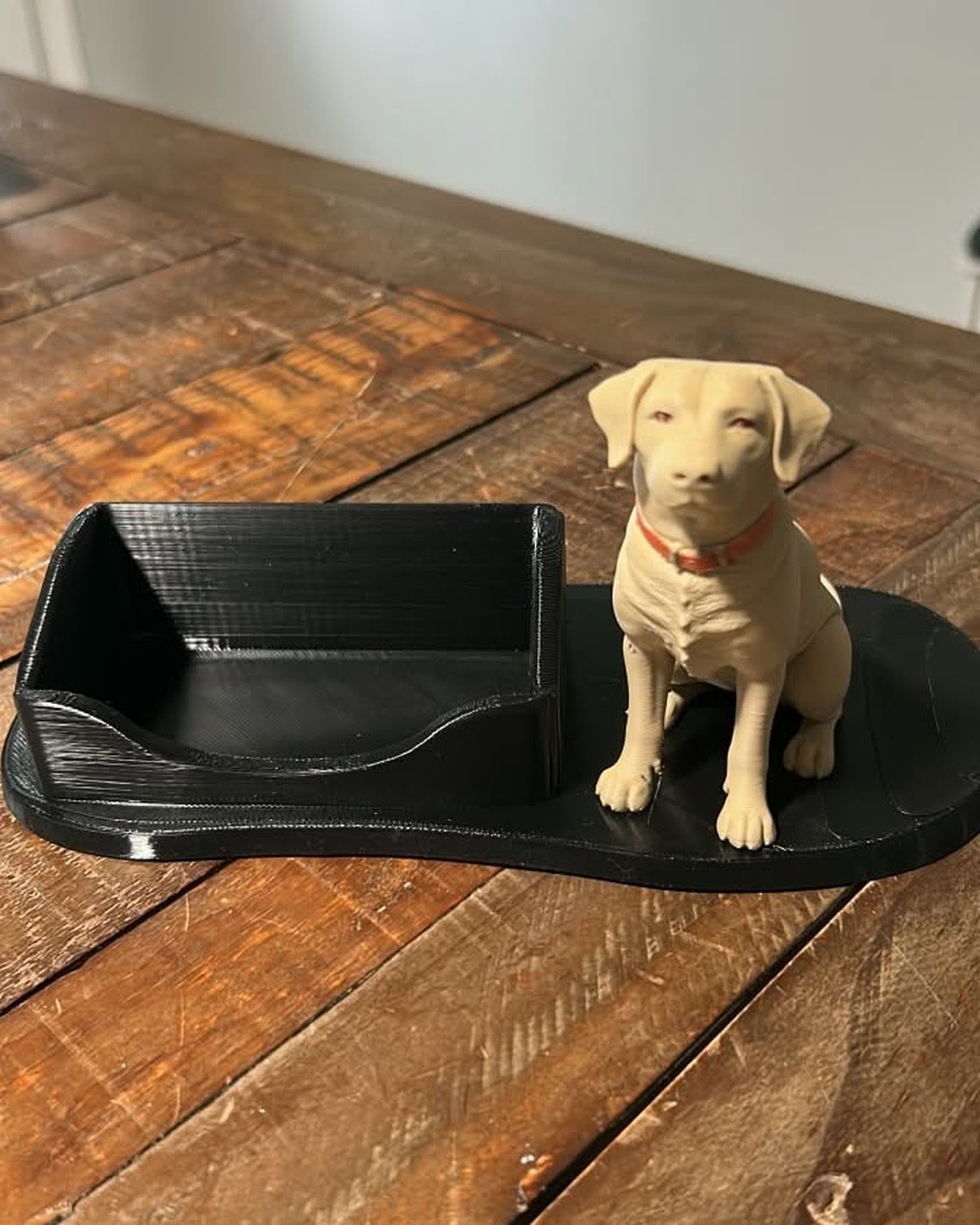 Custom 3D-printed desk accessory: business card holder with a beige Labrador figurine on a rustic wooden surface.