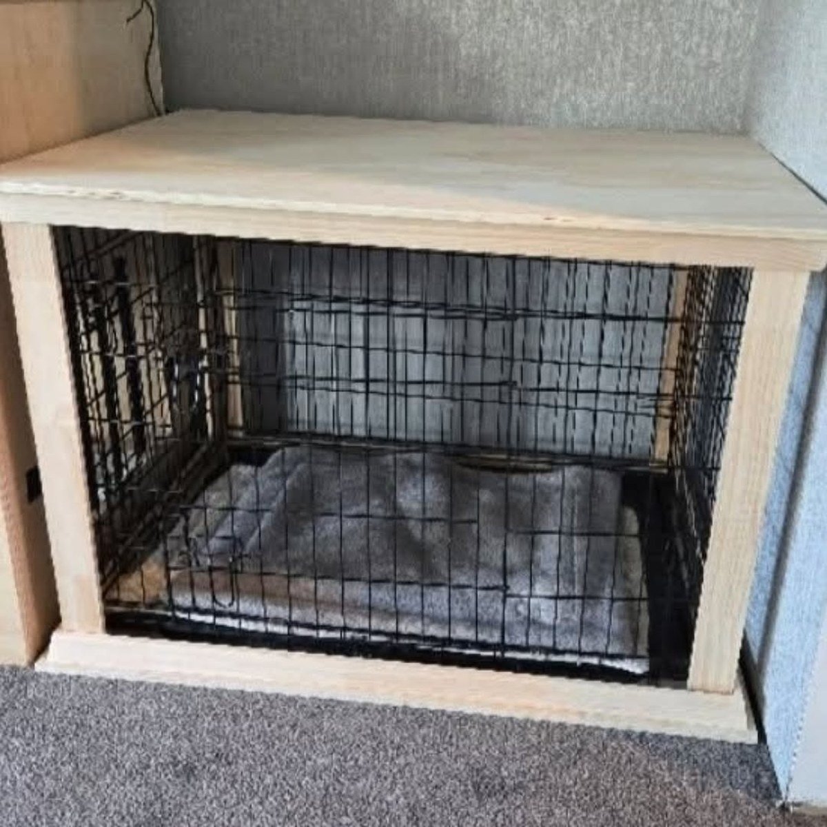 Handmade light-wood crate surround fitted over a metal wire dog crate, forming a table-like enclosure with flat top. No readable text per visual summary.