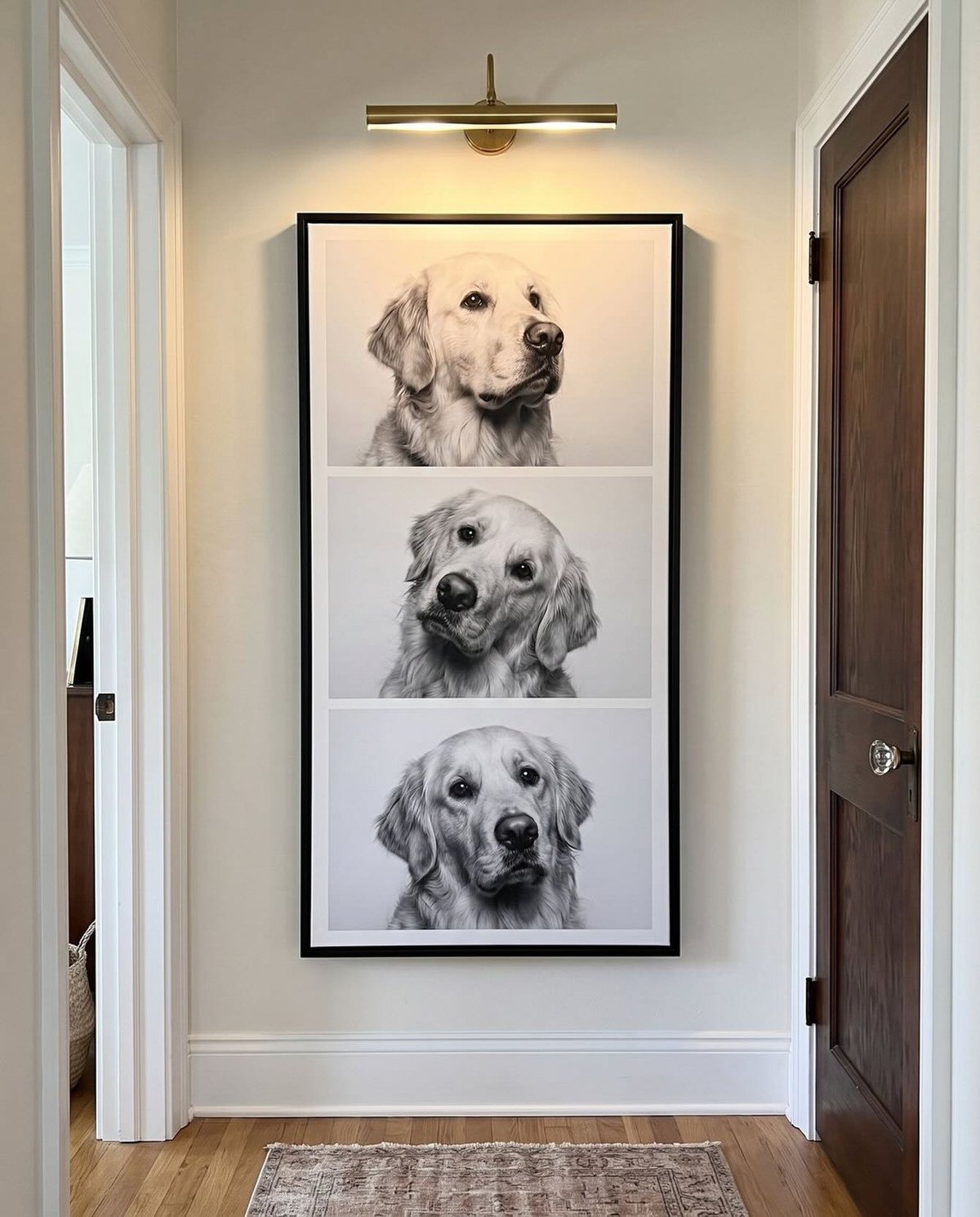 Interior hallway with a large black-framed artwork of three stacked black-and-white golden retriever photos.