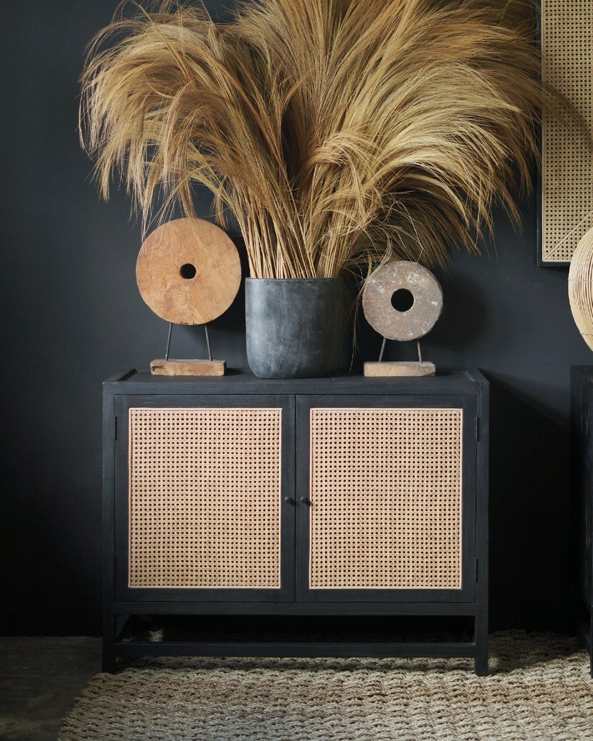 Black sideboard with natural woven cane-webbing doors illustrating the rattan-front look (cabinet, not a crate). No readable text per visual summary.