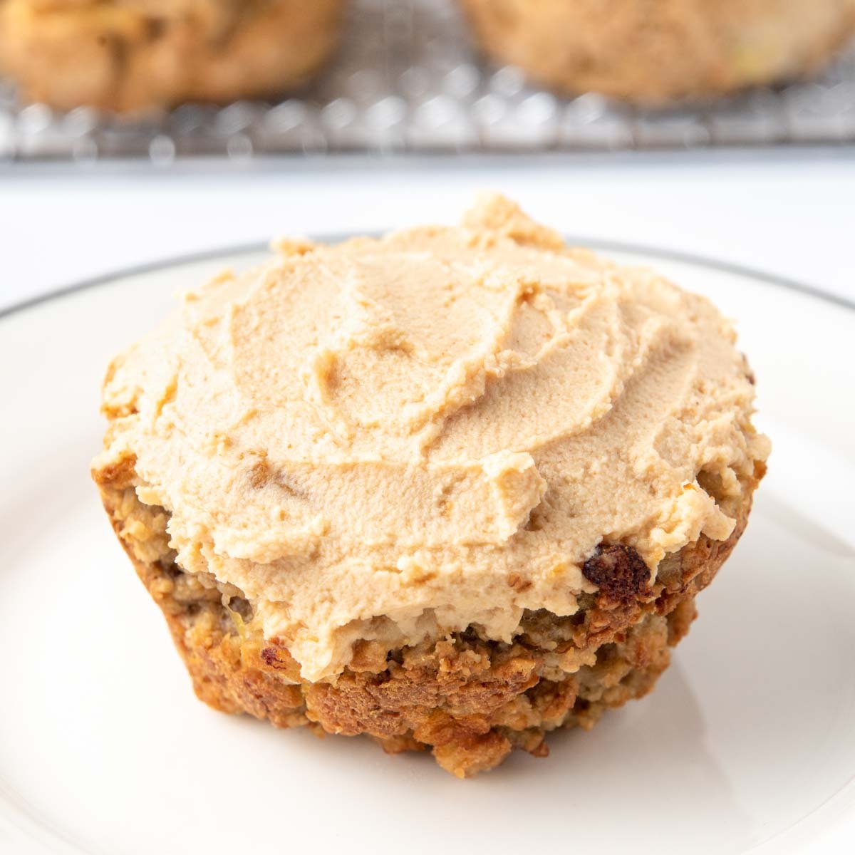 Apple pupcake with peanut butter yogurt frosting on a white plate